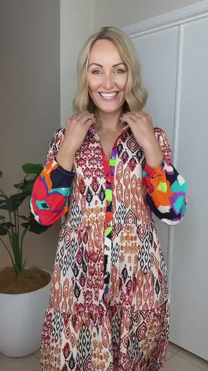 VIDEO OF MODEL SHOWING OFF THE TOZI MAXI DRESS AND DISPLAYING THE TIES, BALLOON SLEEVES AND BRIGHT FLOWER PRINT AND GEOMETRIC PRINT